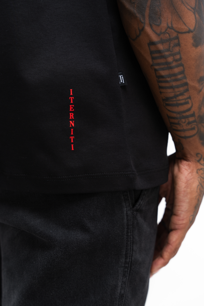 Camiseta oversize negra con letra roja para outfit urbano en Colombia.