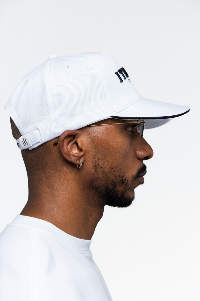 Gorra blanca de Iterniti en vista lateral, con ajuste y diseño urbano
