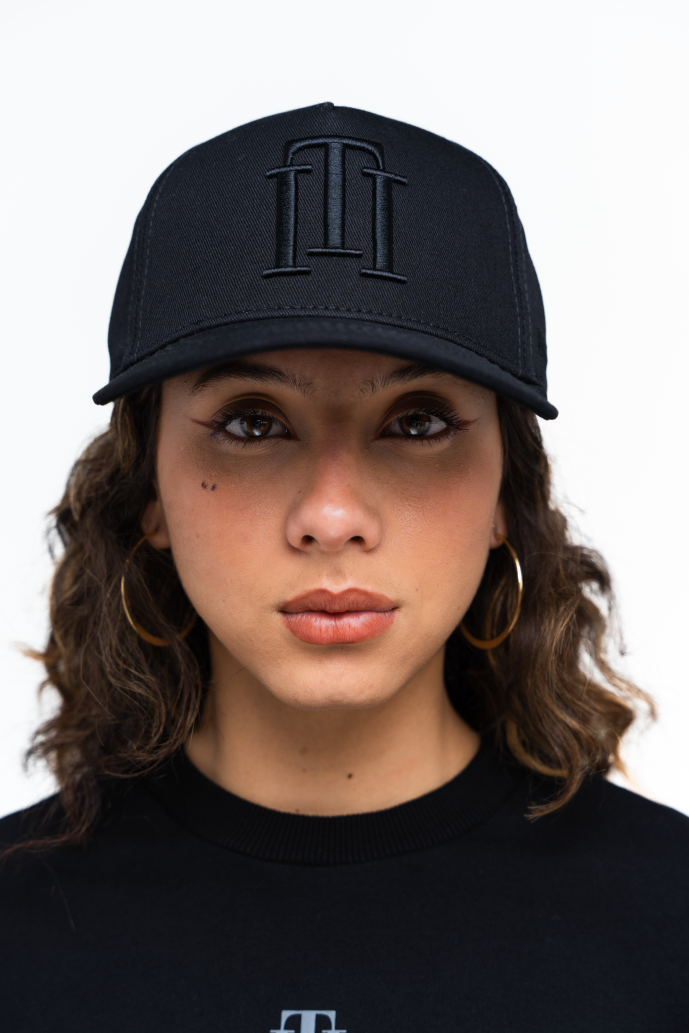 Mujer usando la gorra negra de Iterniti con correa de cuero, resaltando su diseño premium y ajuste perfecto