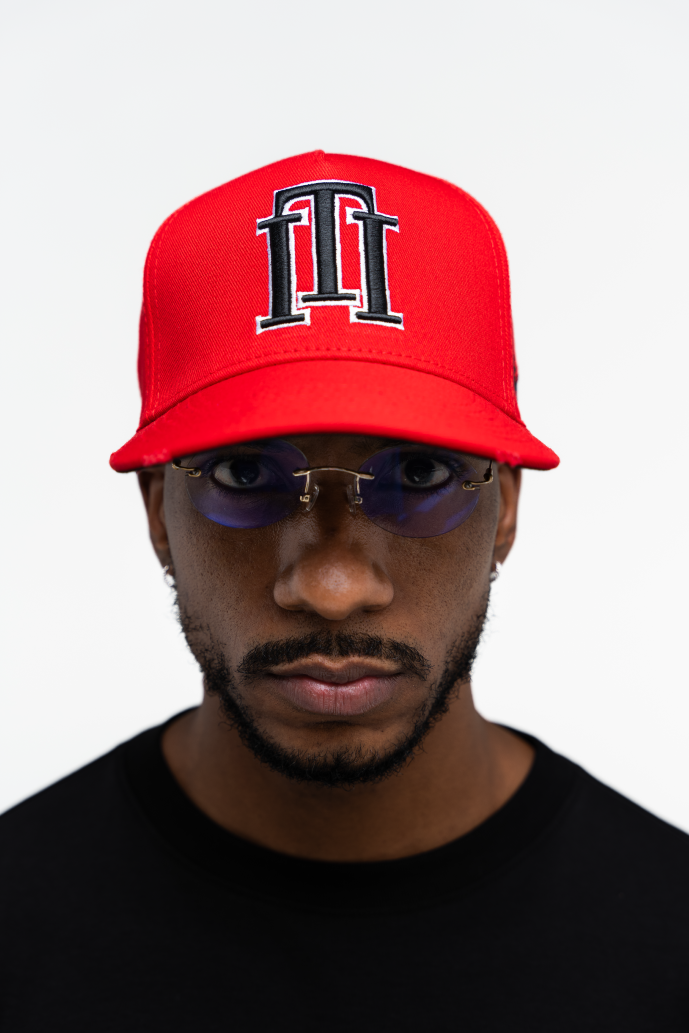 Vista frontal de la gorra roja de Iterniti con isotipo negro y borde blanco, estilo llamativo y moderno