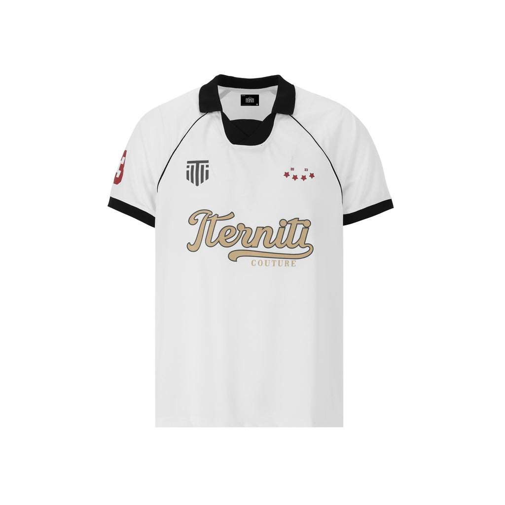 Victory Jersey de Half time fusiona la estética deportiva con el lujo urbano. Confeccionado en un tejido técnico de estructura impecable, presenta un diseño limpio en color blanco con cuello y ribetes negros en contraste. Destaca por su logo frontal en dorado metálico y detalles gráficos laterales, junto con el sello "All in. No limits." en la espalda. Su corte oversize garantiza comodidad absoluta y un acabado sport-luxe único para elevar cualquier outfit.