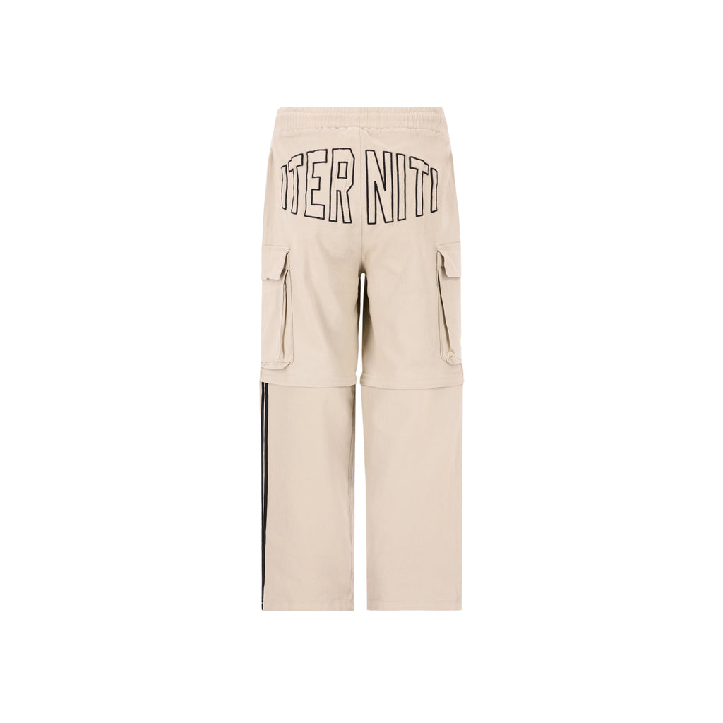 Desert Cargo pant/short de Half time es la pieza definitiva de ingeniería urbana: un diseño 2 en 1 que transforma su corte baggie de silueta holgada y relajada en un short funcional en segundos. Confeccionado en un tono beige versátil, destaca por sus amplios bolsillos laterales estilo cargo y un estampado posterior de alta densidad en negro que aporta una textura táctil premium. Su ajuste baggie garantiza un estilo vanguardista y comodidad absoluta, convirtiéndolo en la prenda esencial.
